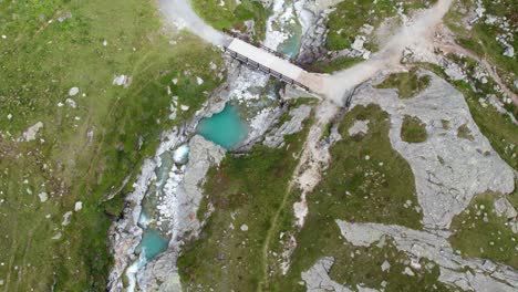 revealing aerial shot of turquoise blue mountain lake high up in swiss alps, beautiful mountain scenery with blue water and green scenery