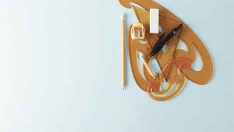 compass, pencil, sharpener, eraser and rulers with copy space on white background, slow motion