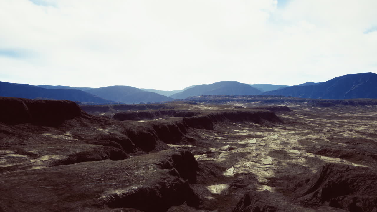Vast volcanic landscape stretches under a cloudy sky at dawn