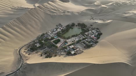 orbit shot of isolated town surrounded with sand dunes, ica, huacachina, peru