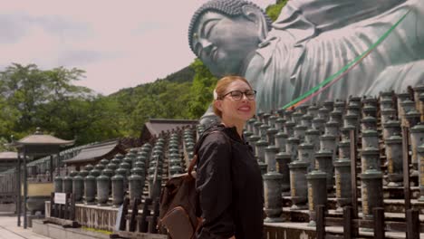 Lateinische-Junge-Schöne-Frau-Genießt-Riesigen-Bronzenen-Buddha,-Der-In-Fukuoka,-Japan,-Meditation-Und-Zen-Tourismus-Liegt