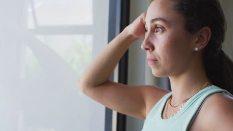 Thoughtful-caucasian-woman-is-looking-out-the-window