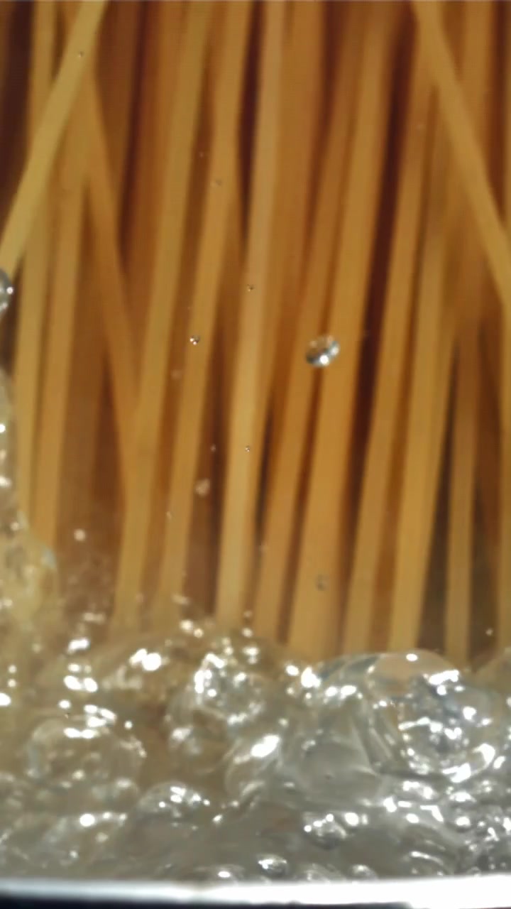Primo piano di spaghetti che cuociono in acqua bollente
