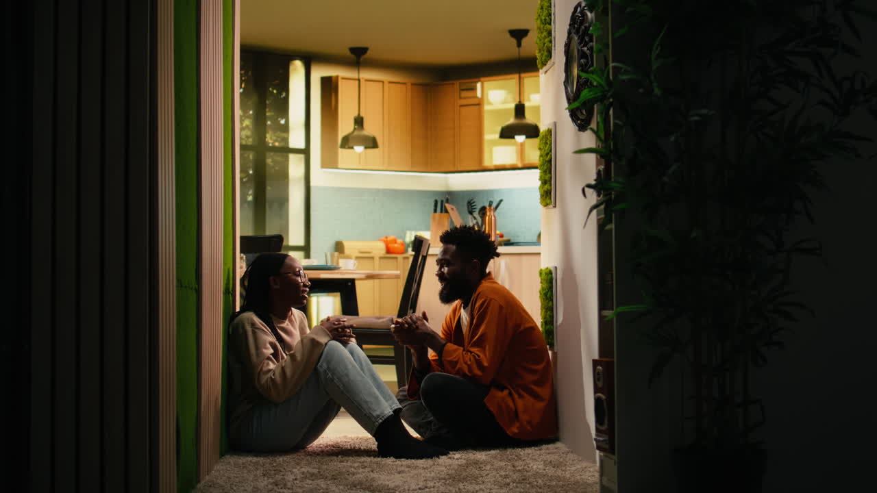 African american couple chatting about domestic life sitting on the floor