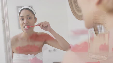 animación de pétalos de rosa flotantes sobre una mujer biracial cepillándose los dientes en el baño