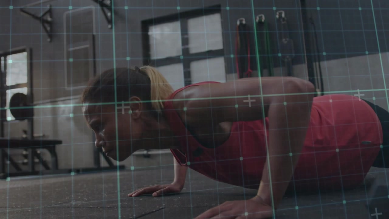 Woman trainee doing push-ups from high plank on gym floor, grid overlay tracking form for fitness