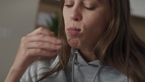 caucasian woman with bulimic sitting at the sofa and eating unhealthy food.