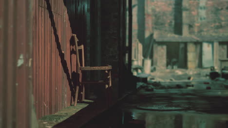 old wooden chair sitting on a sidewalk in a narrow alley