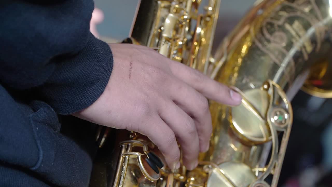 Primo piano della mano destra di un sassofonista tenore durante un'esibizione.