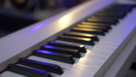 silver electronic piano with colored lighting - slow motion shot