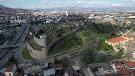 Drone-video-of-the-castle-standing-on-the-riverbank-with-bridges-surrounded-by-old-houses-in-the-city-center-shot-aerial-Skopje-Macedonia