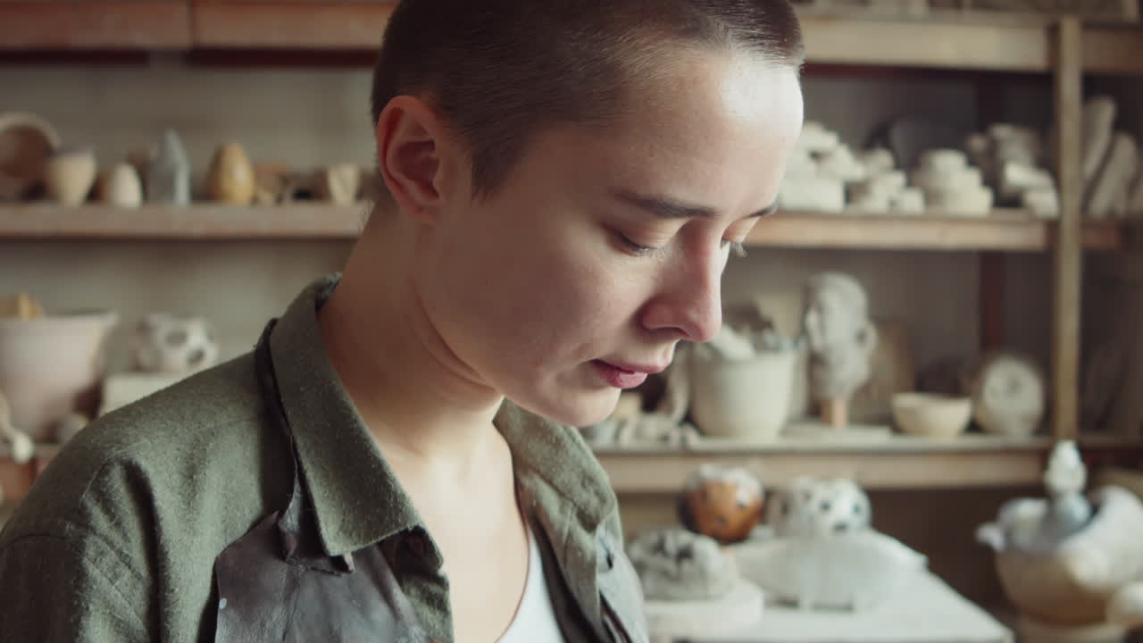 mujer usando teléfono inteligente en un taller de cerámica