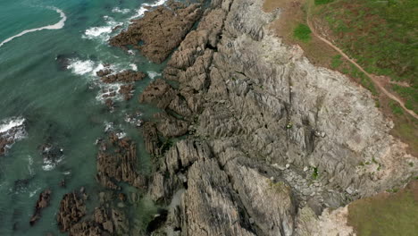 toma aérea que se inclina hacia arriba para revelar un promontorio costero en north devon en un día de verano