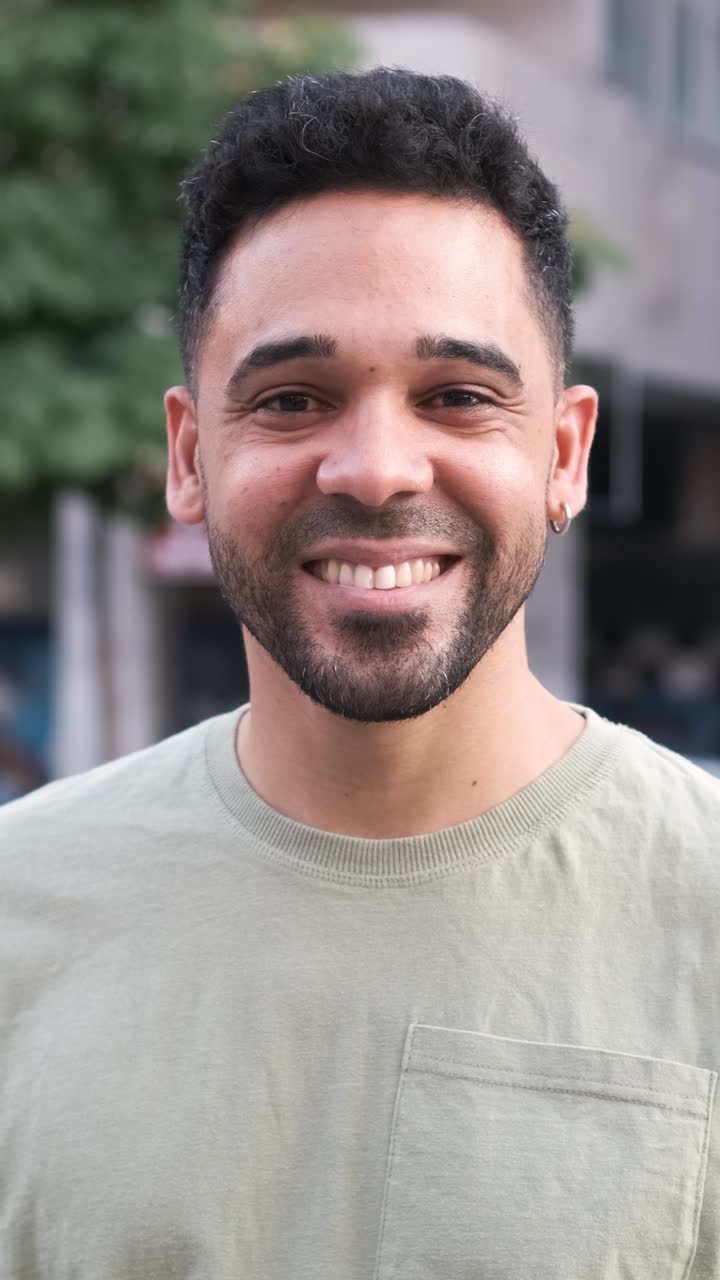 Happy man smiling and nodding head while standing on city street