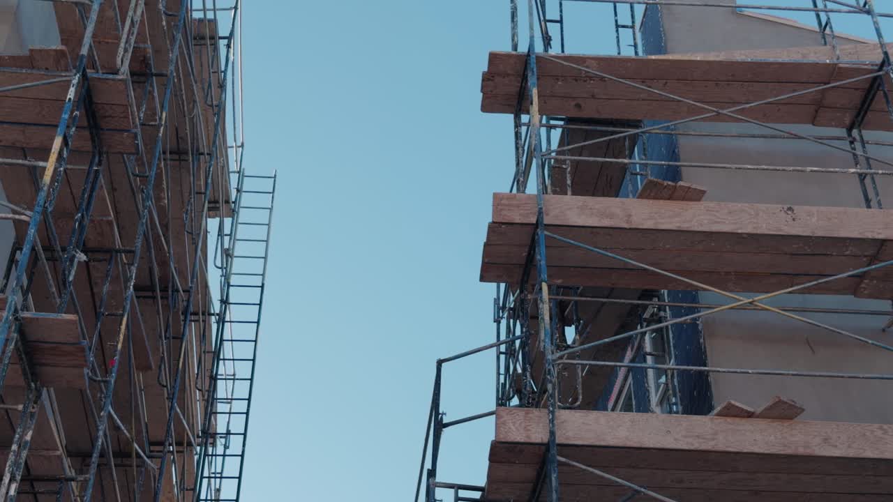 Smooth exterior pan between multi story housing blocks wrapped in jobsite scaffolding