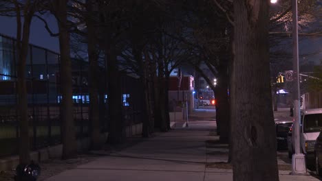 View-down-an-empty-sidewalk-in-New-York-City-at-night