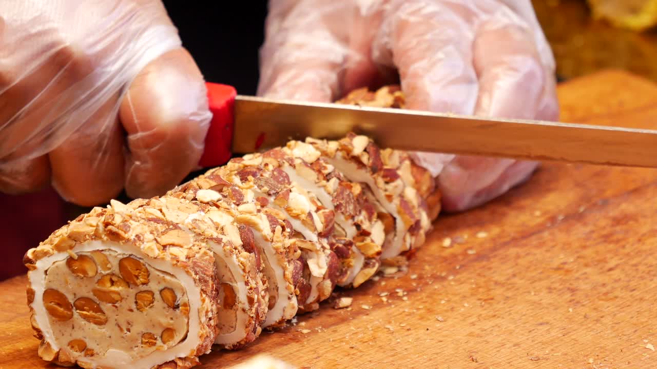 스페인의 전통적인 투로론 (turrón) 을 잘라내고 있다.