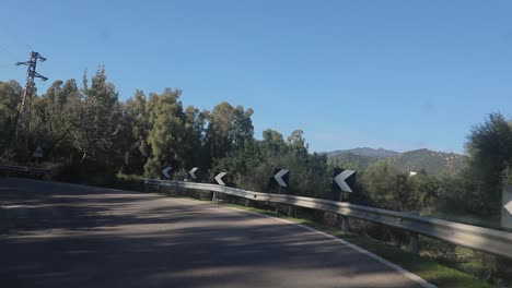 Zeitlupe-Einer-Kurvenreichen-Autobahn-über-Einen-Berg-Voller-Bäume-Und-Sicherheitsverkehrszeichen-Der-Straße