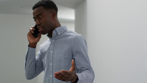 young businessman in office talking on mobile phone looking frustrated and angry 1