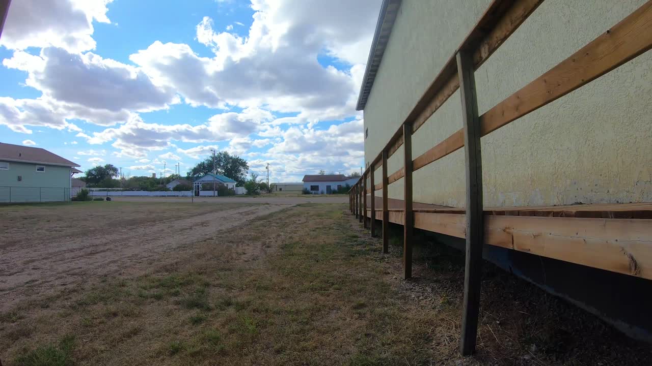 타임  ⁇ 스 - 거리의 전망과 몇 대의 자동차가 구름이 많은 날을 지나가는 작은 마을의 램프를 가진 노란색 건물