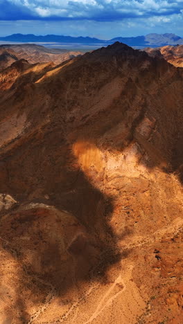 part of the brown mountain shaded by the big cloud. dry mojave landscape from drone footage. vertical video