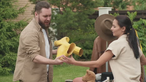 man looking at rubber boots at yard sale