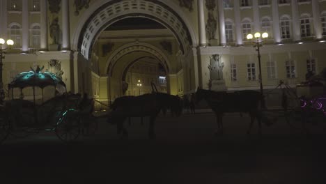 horses and carriages at the winter palace at night