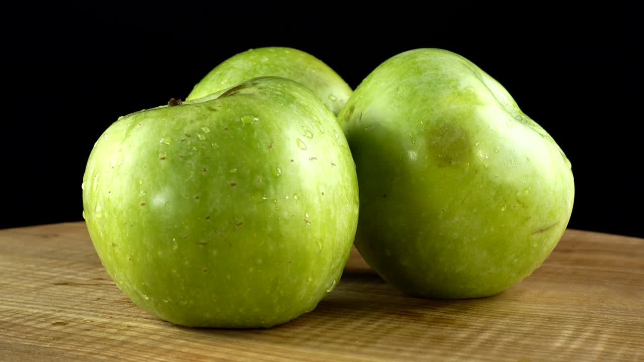 Æbler på sort baggrund. Skærebræt i bevægelse.