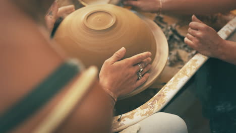 two unrecognisable woman working with clay