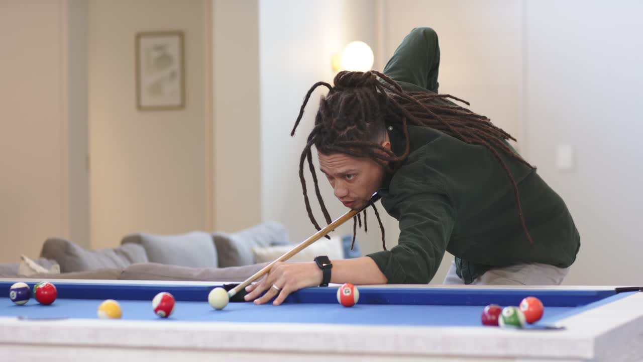 Depois de escanear bolas, homem afro-americano acertando a bola branca na mesa de sinuca para encaçapar as bolas