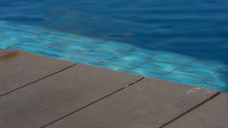 vacation holiday moment with wooden deck and blue mosaic swimming pool