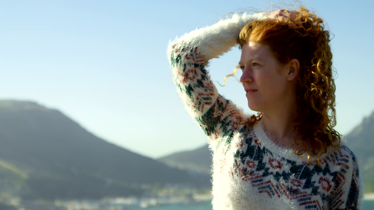 시골 4k에서 머리카락에 손을 들고 서있는 여성