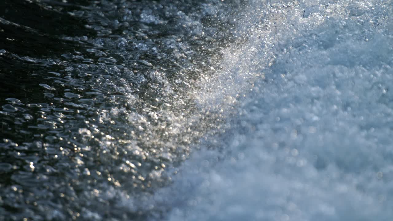 Super slowmotion of water stream splashing with bubbles and reflections