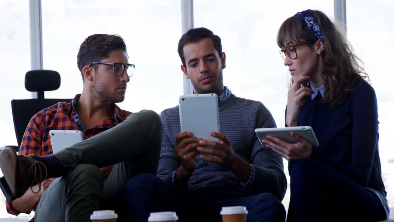 ejecutivos discutiendo sobre una tableta digital