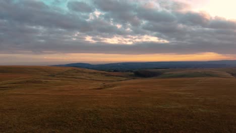 incredible sunset dynamic blue tinted cloudscape over welsh hills with swansea in far distance and open moorland. adventure, travel drone footage 4k.