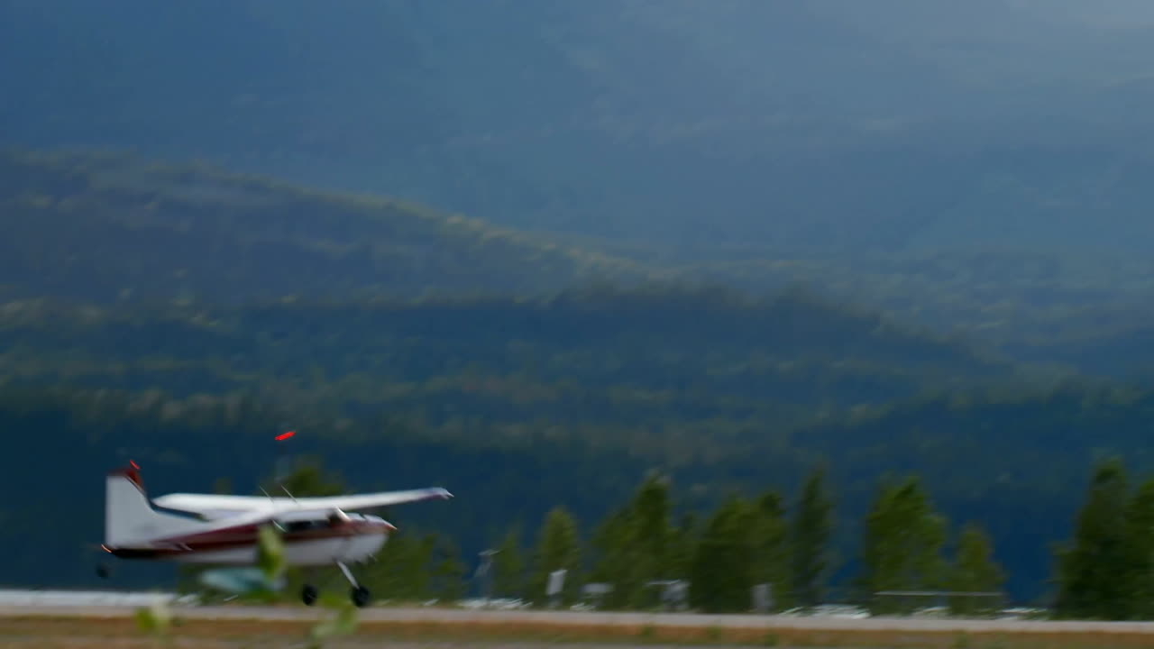 Airplane taking off from runway, animation of forested mountains in background