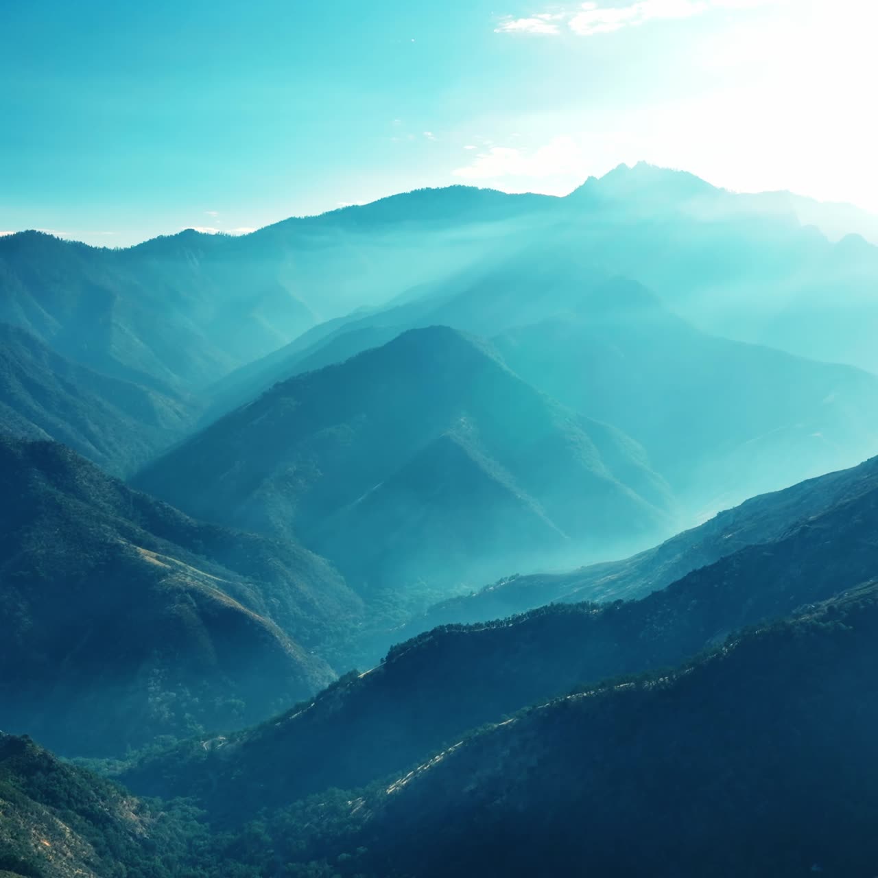 Beautiful mountains covered with greenery in the rays of bright sun. Gorgeous rocks in the blue light
