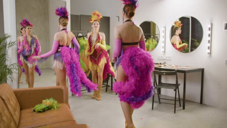 three showgirls dancing in the backstage