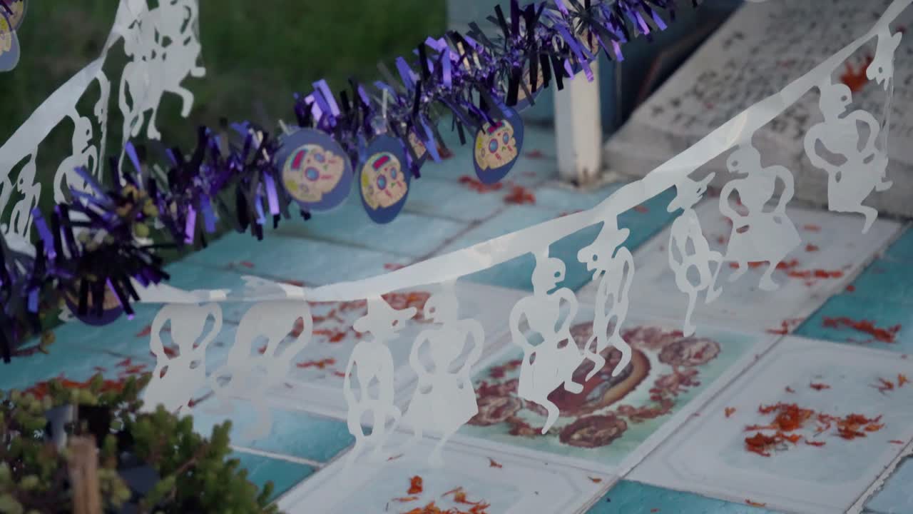 Bir mezar üzerindeki rengarenk çelenkler ve süslemeler, anıları ve kutlamayı çağrıştırıyor