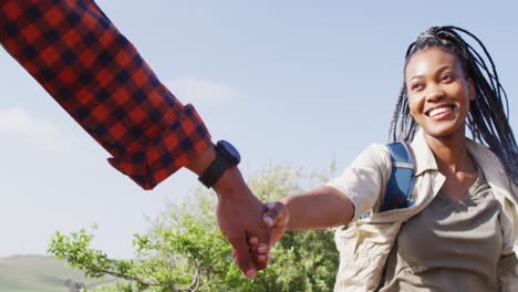 feliz pareja afroamericana con mochilas, caminando juntos en un día soleado, cámara lenta