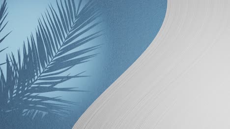 White-plaster-wave-by-light-blue-texture-background-with-palm-frond-shadow