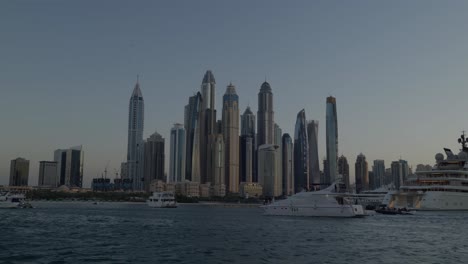 vista de la línea del cielo de la ciudad de dubái desde un viaje en yate, hermosa puesta de sol impresionante, vista estética con grandes rascacielos, torres, burj khalifa