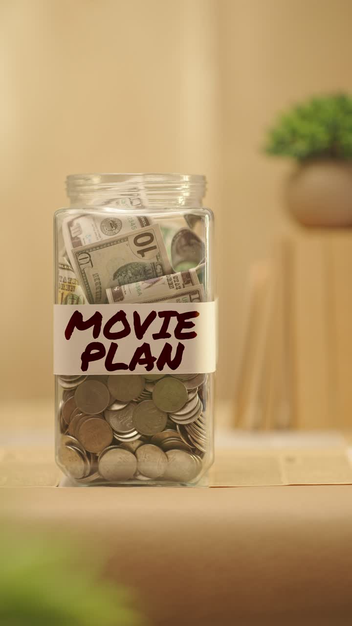 VERTICAL VIDEO OF PERSON SAVING MONEY FOR MOVIE PLAN