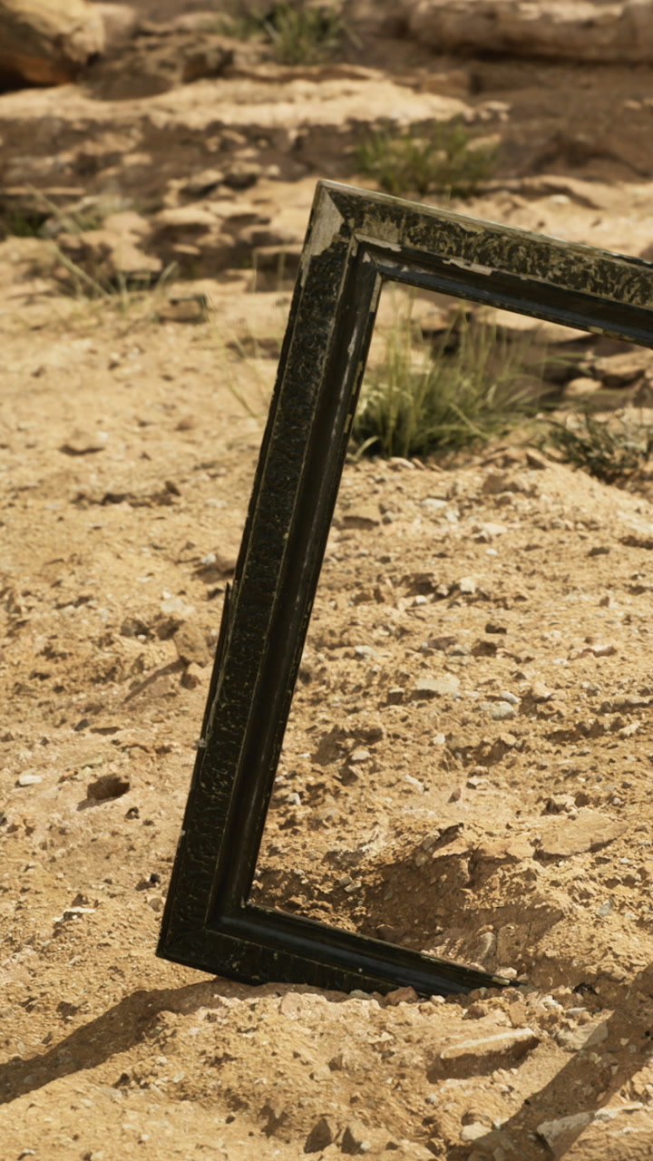 Desert frame stands alone amidst rugged terrain under a bright sky