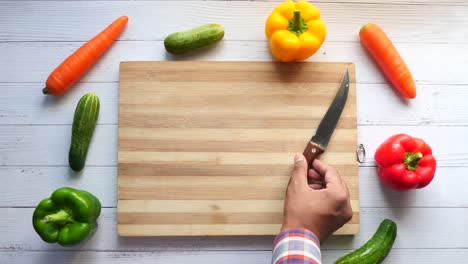 preparing fresh vegetables: carrots, cucumbers, and bell peppers