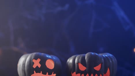 video of halloween carved pumpkins and smoke with copy space on blue background