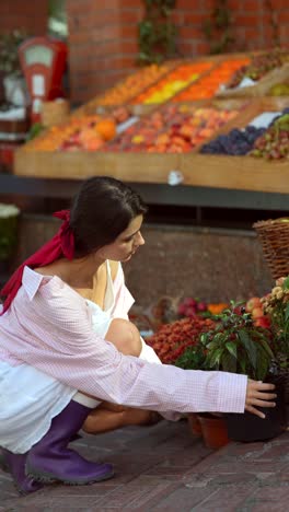 woman in a market examining plants