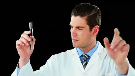médico usando una pantalla digital mientras examina un químico en un tubo de ensayo