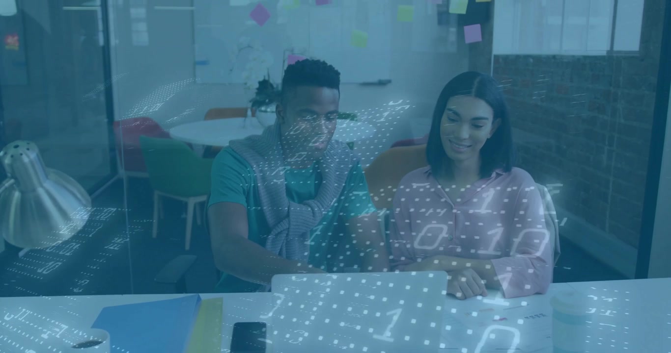 Man explaining data visualization with binary overlay appearing and woman typing in tech office