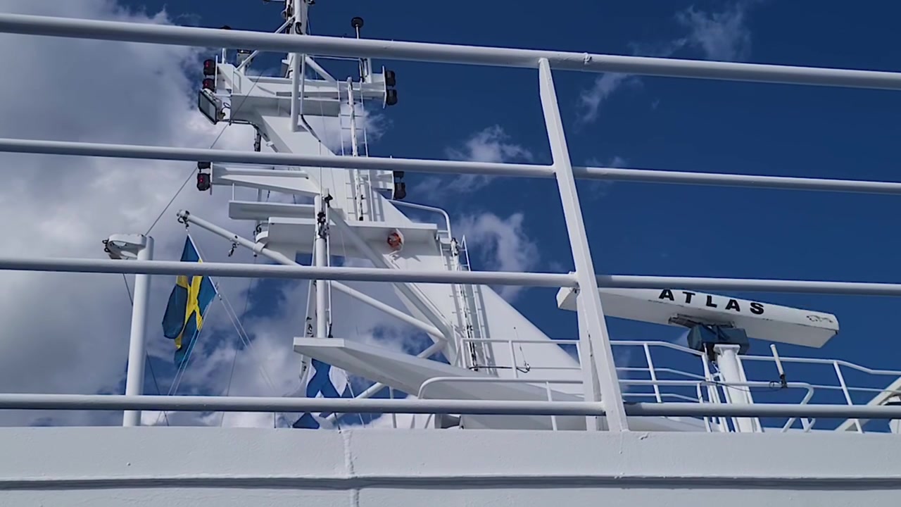 Sweden and Finland National Flags Waving on Top of Cruise Ship on Sunny Day